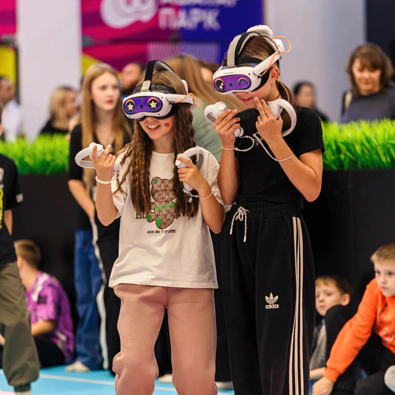 Семейный отдых в VR-парке: две девочки играют в шлемах