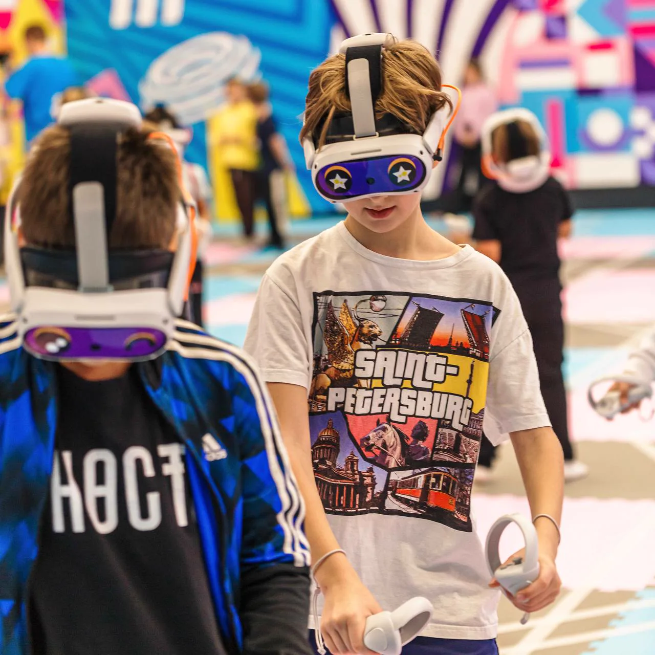 Двое подростков в VR-шлемах проходят игру на арене